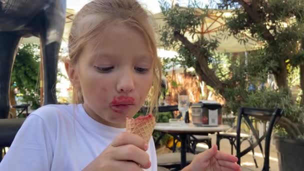 Κοντινό Πλάνο Ένα Αστείο Κοριτσάκι Τρώει Παγωτό Φράουλα Ένα Χωνάκι — Αρχείο Βίντεο