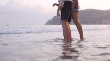 Çocuklu bir anne, bir oğlan ve bir kız, ayaklarını denizde ıslatıyor. Türkiye, Alanya, Eylül