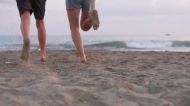Bir anne ve oğul kumsalda denize doğru koşuyor. Arkadan bak, yavaş çekim, Türkiye, Alanya. Aile Turizmi