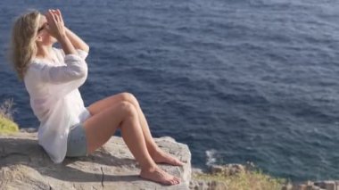 Yakından, güzel bir turist kadın bir uçurumdan denize bakıyor. Türkiye, Gazipasa