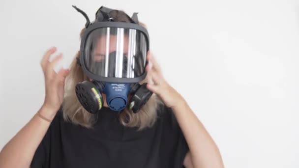 一个女人在害怕核战争的时候会戴上防毒面具 一个女人戴上防辐射的防毒面具 — 图库视频影像