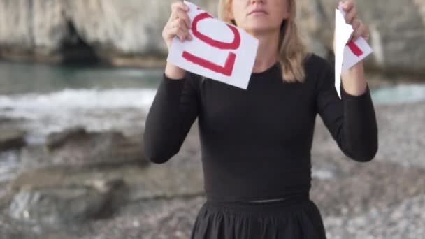 Κοντινό Πλάνο Μια Γυναίκα Σκίζει Μια Αφίσα Πάνω Στην Οποία — Αρχείο Βίντεο