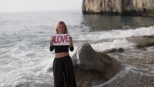 Šťastná Žena Stojí Moře Drží Rukou Papír Nápisem Láska — Stock video