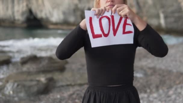 Zblízka Žena Pozadí Moře Roztrhá Plakát Nápisem Love — Stock video