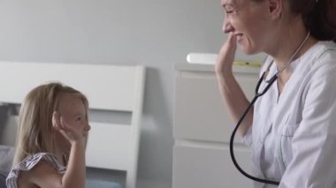 Doktor küçük hastayı iyileşmesi için tebrik ediyor. Dost canlısı bayan doktor küçük bir kıza beş dolar verdi..