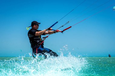 Hurghada / Mısır - 15 Nisan 2022: Uçurtma uçurtma adam güneşli bir günde denizde