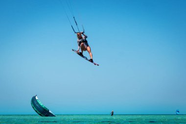 Hurghada / Mısır - 15 Nisan 2022: Uçurtma uçurtma, kadın denizin altında uçurtmaya atlıyor