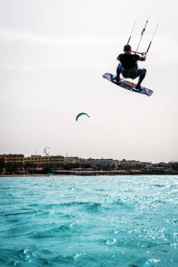 Hurghada / Mısır - 15 Nisan 2022: Uçurtma uçurtma, adam denizin altında uçurtmaya atlıyor