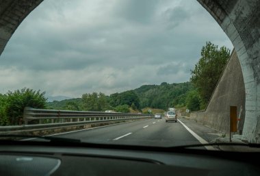 Dağlardaki tünellerden geçerek manzara ve dramatik gökyüzü boyunca. Ulaşım altyapısı. İtalyan otomotiv 