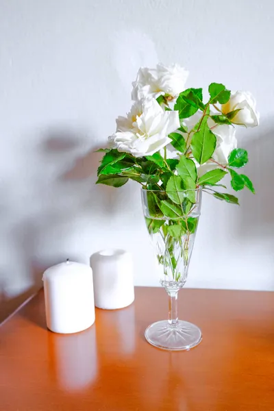 花瓶里有白色的玫瑰 木头上有白色的蜡烛 隔着白色的墙 室内设计 家居装饰 — 图库照片
