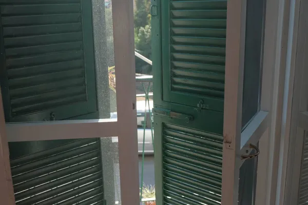 Janelas Brancas Com Persianas Verdes Dentro Edifício Uma Rua Ensolarada — Fotografia de Stock