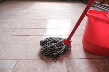 Döşemede paspas ve kırmızı temizlik kovası yakın çekim için hazır. Temizlik servisi. İç mimari
