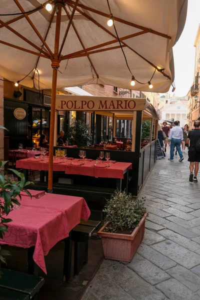 2021年7月意大利塞斯特里 莱文特 Sestri Levante 空气中的餐厅 在大伞下 街对面点着灯 红桌布餐厅家具 — 图库照片