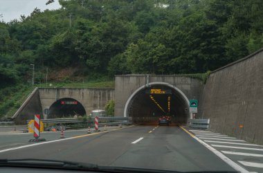 Şehirdeki yeraltı tünelinde arabalar çalışıyor. Şehir altyapısı. Dağların arasından otoban