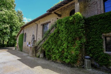 Sarmaşık yaprakları, heykeller, merdivenler içinde Grazzano-Visconti kale duvarları. Ortaçağ mimarisi, bina. İtalya, Emilia-Romagna