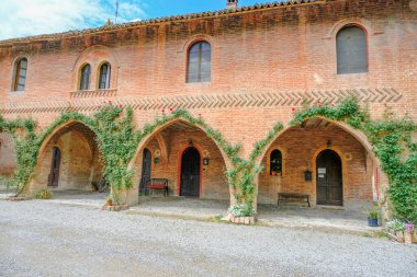 Bitkilerle kaplı üç kemerli Grazzano-Visconti ortaçağ binası. İtalya, Piacenza, Emilia-Romagna