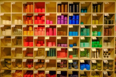 Farklı şekillerde ve ölçülerde mumları olan ahşap raflar.. 