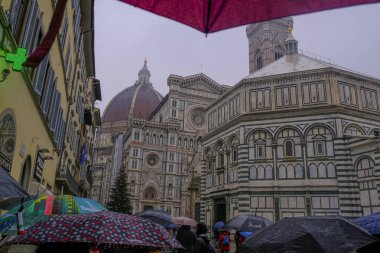 Floransa, İtalya: Santa Maria del Fiore Kubbesi, Florence Baptistery dramatik gökyüzü boyunca yakın çekim, yağmurlu bir günde şemsiyeler. 