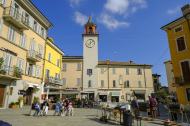Ekim 2021 Langhirano, İtalya: Piazza, Meydan Garibaldi, Kule saati, eski kasaba, güneşli bir günde insanlarla pazar