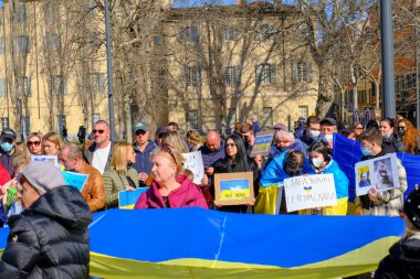 Şubat 2022 Parma, İtalya: Eski kentte savaşa karşı gösteri. Binalar ve mavi gökyüzü üzerinde Ukrayna bayrağı. Ukrayna 'yı posterler, pankartlar ve bayraklarla destekleyenler