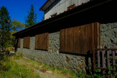 Ormandaki ahşap panjurlu eski tuğla ev. Kırsal yaşam. Kırsal kesimde tatil. Dağlara sığınmak.