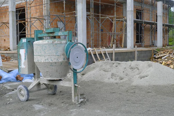Yakın plan çekimde beton karıştırıcı. Aletleri ve binaları olan bir inşaat alanı. İnşaattaki ev, yakın plan. İnşaat alanı. İnşaat çalışmaları