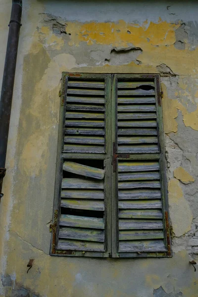 old broken wooden window in the old wall. Damaged building background. haunted home
