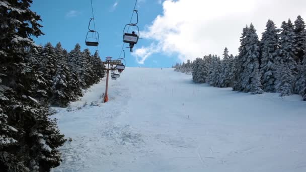 Skilift beweegt over de besneeuwde berg en de zon ray timelapse. — Stockvideo