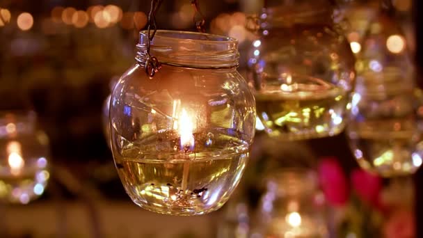 在高透明度的玻璃中燃烧着小白蜡蜡烛 在模糊的背景上挂着颤动的火焰 — 图库视频影像