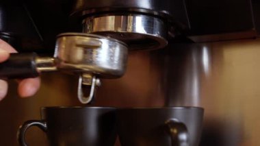 Kahveyi karıştırıyorum. Erkek Eller, kahve tabletine taze öğütülmüş kahve bastırmak için kurcalayıcı kullanıyor.,