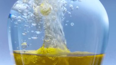 Yağ arka planı. Güzel sarı, turuncu yağ kabarcıkları suyun içinde mavi arka planda sıçrıyor..