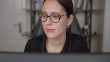 Bilgisayarda çalışan kadın. Güzel bir kadın bilgisayarında çalışıyor. Kadın internete bağlandı ve internette sörf yapıyor. Ekranı okuyor, klavyede yazıyor. Muhtemelen çalışıyordur, çalışıyordur, öğreniyordur..