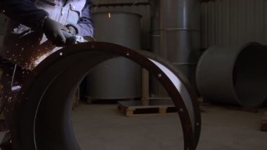 Grinder 'la Çalışmak, ağır çekimde metal kesen bir adamın yakın çekim görüntülerini sergiliyor..