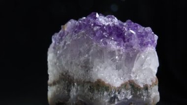 Ametist Yakından. Koyu arkaplanda dönen bir Ametist kayasının yakın görüntüsü.