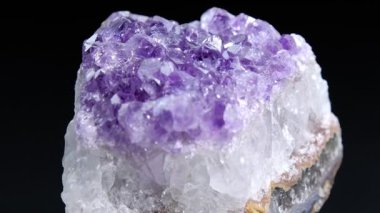 Ametist Yakından. Koyu arkaplanda dönen bir Ametist kayasının yakın görüntüsü.