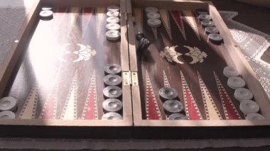 Tavla, geleneksel Türk tavla oyun tahtası görüntülerinin sergilendiği harika bir stok videosu. Yavaş çekimde zar atıyor. Bu videoyu masa oyunlarıyla ilgili her projede kullanabilirsiniz.. 