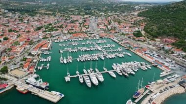 Cesme Marina. Bu hava videosu, Türkiye 'de Ege Denizi' nde dört liman şeridi dolusu yat ve tekne bulunan Cesme Marina 'daki yatları gösteriyor..