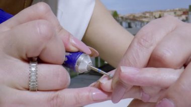 Manikürcü Tırnak Emici. Bu stok videosu bir manikürcünün ellerinin müşterinin tırnak derisini yüzüşünü gösteriyor..