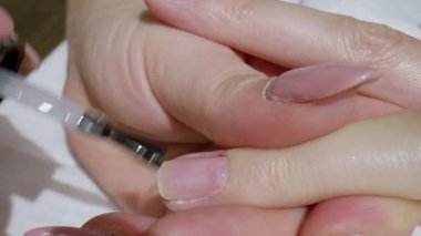 Tırnak cilası. Manikürcülerle bir tırnak cilasının yakın çekimi..