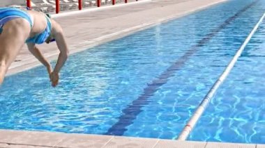 Side view of woman diving in water while resting at pool in sunny day.