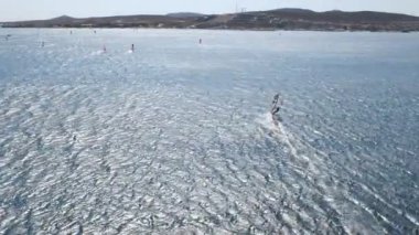 Wind surfers in action. Aerial view of speeding windsurfers. The silhouettes of windsurfers with their magnificent views are having a wonderful day in eme Turkey at sunset.
