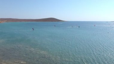 Aerial view of speeding windsurfers with speed ramp effect. The silhouettes of windsurfers with their magnificent views are having a wonderful day in cesme alacati Turkey at sunset.