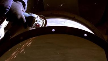Grinder 'la Çalışmak, ağır çekimde metal kesen bir adamın yakın çekim görüntülerini sergiliyor..