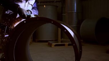 Grinder 'la Çalışmak, ağır çekimde metal kesen bir adamın yakın çekim görüntülerini sergiliyor..