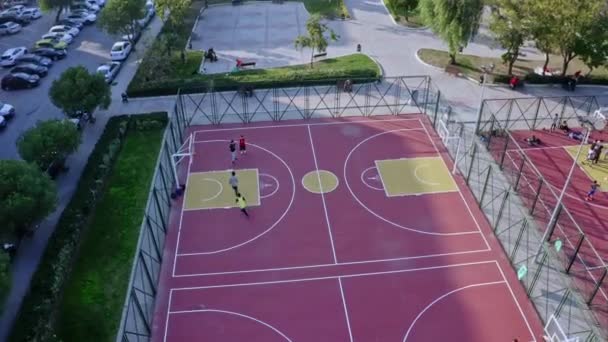 バスケットボールコートの空中ルックス このストックビデオは裁判所でバスケットボールをしている人々の空中ショットを示しています — ストック動画