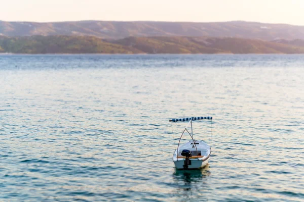 Single boat in sea, visible mountains and island coast. — Stock Photo, Image
