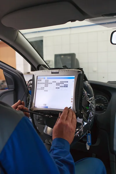 Trabajador de servicio de coche dentro de la computadora de servicio de programación . Imagen de archivo