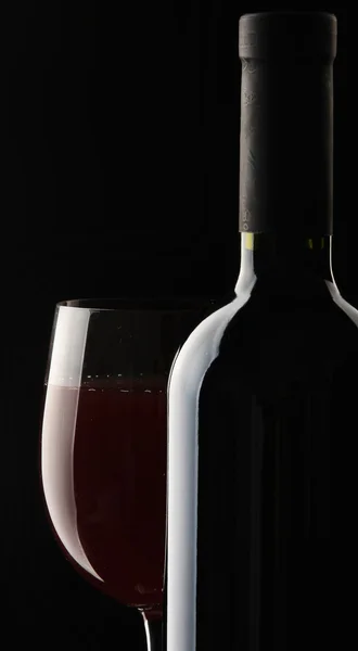 Pohár vörös bort és a borosüveg — Stock Fotó