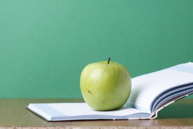 açık bir egzersiz kitap üzerinde yeşil elma