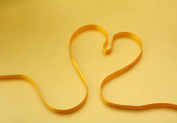A yellow ribbon in the form of a heart — Stock Photo, Image